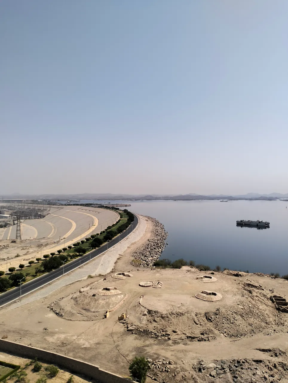 Curving road and rocky embankment beside the water at Aswan High Dam